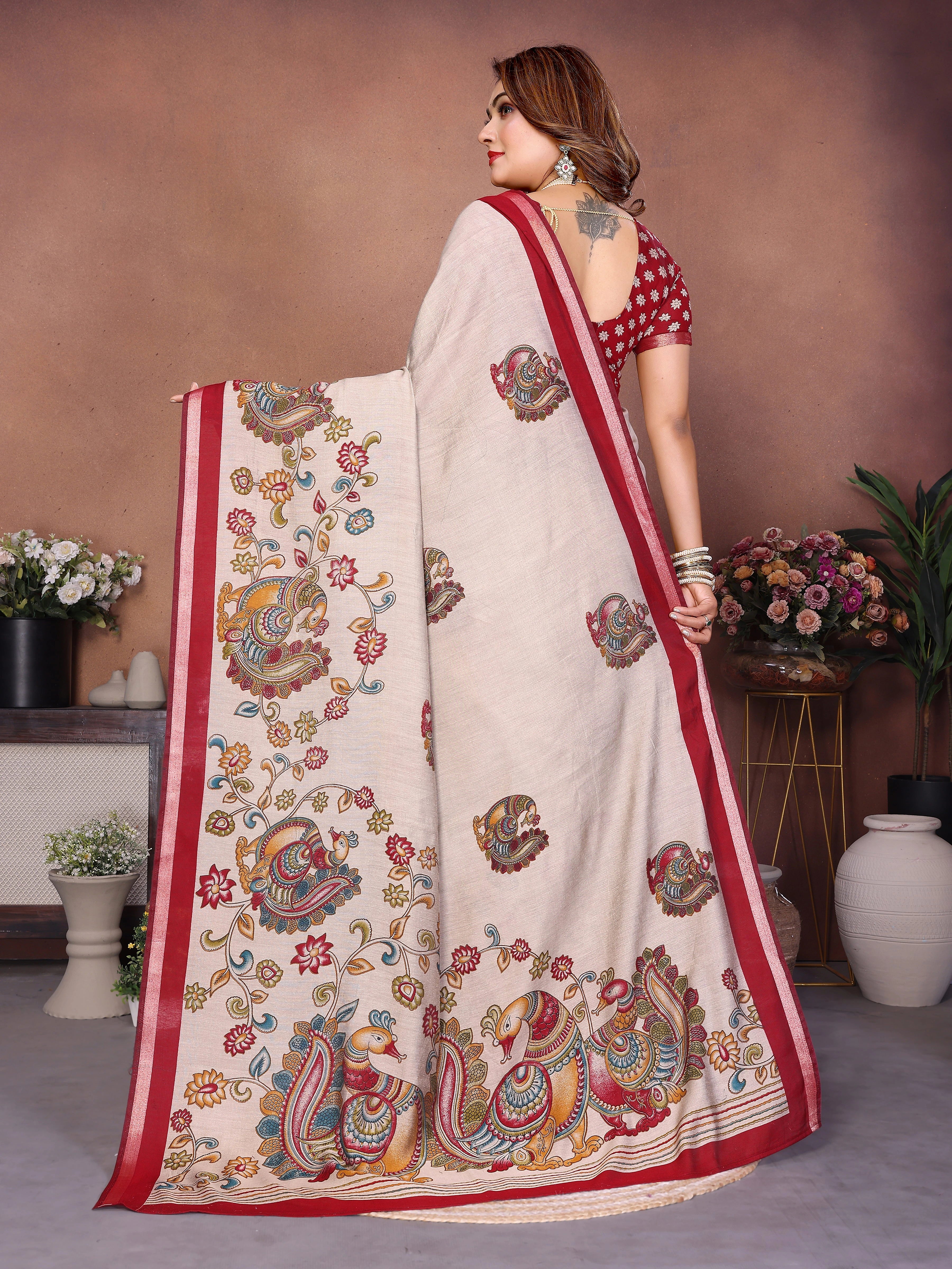 Woman wearing a saree with intricate patterns in a decorated indoor setting